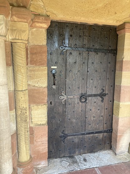 Sandstone wall and wooden door into Astley church St Peter