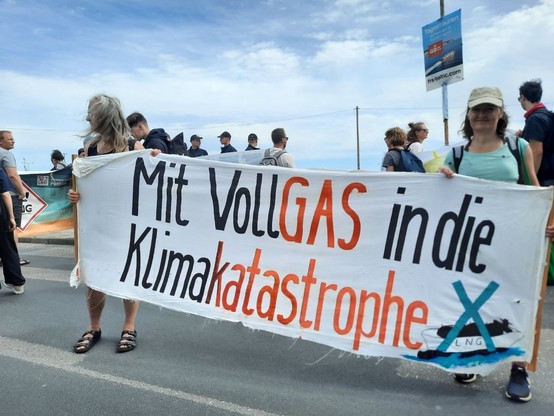 Menschen mit Banner: Mit Vollgas in die Klimakatastrophe 
