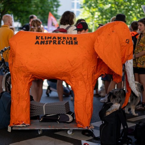 Großer oranger Pappmaché-Elefant. Auf seinem Rücken steht 
