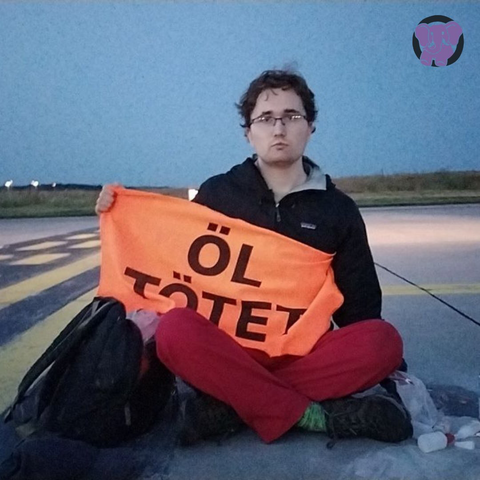 Julian mit Banner auf dem Flughafen: „Öl tötet“