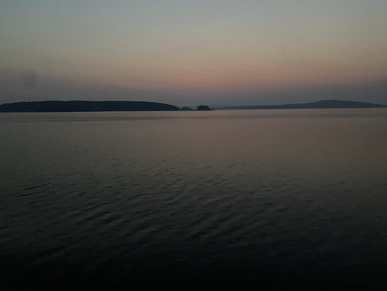 Early dawn light on islands in calm Salish Sea. Lavender through pink and pale blue hues of dawn. 