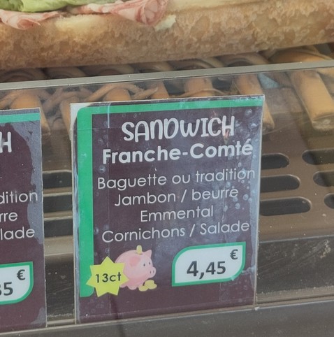 Dans une boulangerie, panneau qui présente un sandwich appelé « Franche-Comté » avec rien de franc-comtois dedans et en particulier, avec de l'Emmental suisse