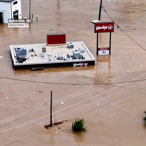 Muddy floodwaters from Hurricane Helene cover the streets in Asheville, North Carolina, with a Wendy's restaurant submerged almost to the rooftop.